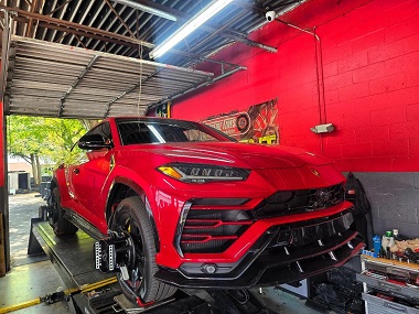 red car on the wheel alignment rack at the Extreme Tires physical location in Sunrise, Florida